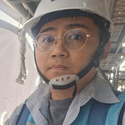 Engineer Tsai on a scaffold, wearing a hard hat and safety harness